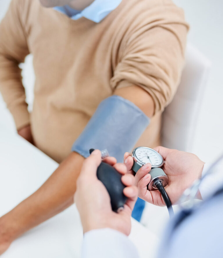 High angle shot of a male doctor taking a patients blood pressure.