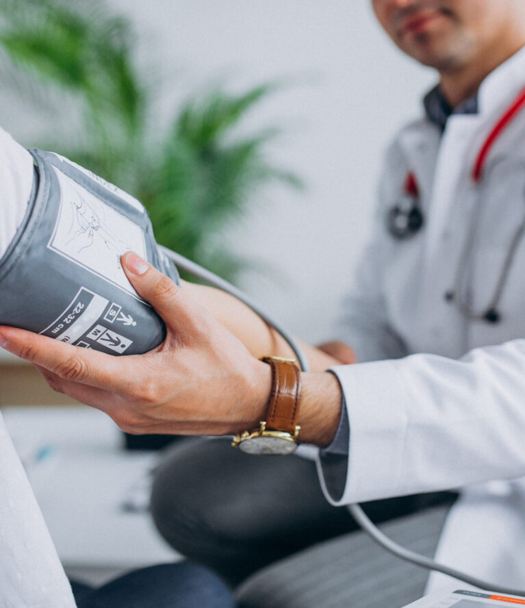 Young male psysician with patient measuring blood pressure